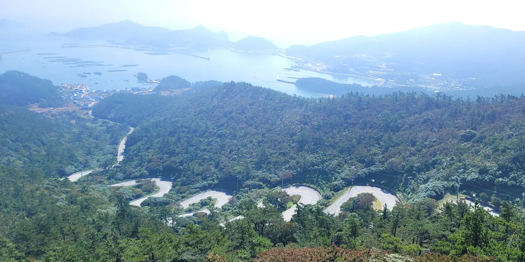 The twelve-bend road folding down the hillside on Heuksando, the harbour and the sea beyond