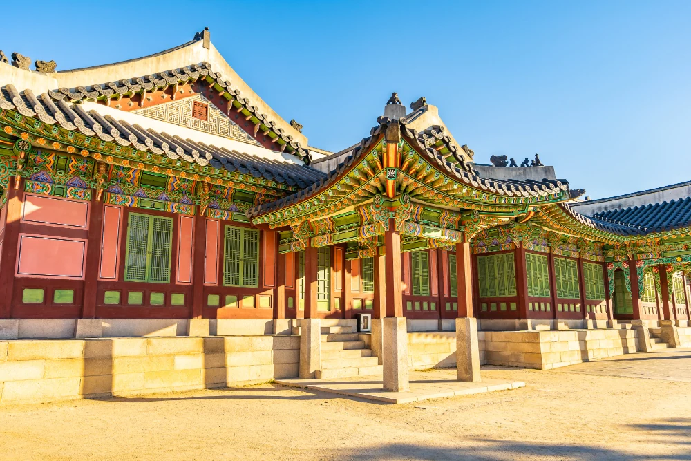 Palace hall with painted eaves above a wide gravel courtyard