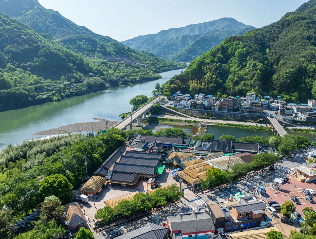 River, sandbar and two bridges seen from above with market buildings along the bank