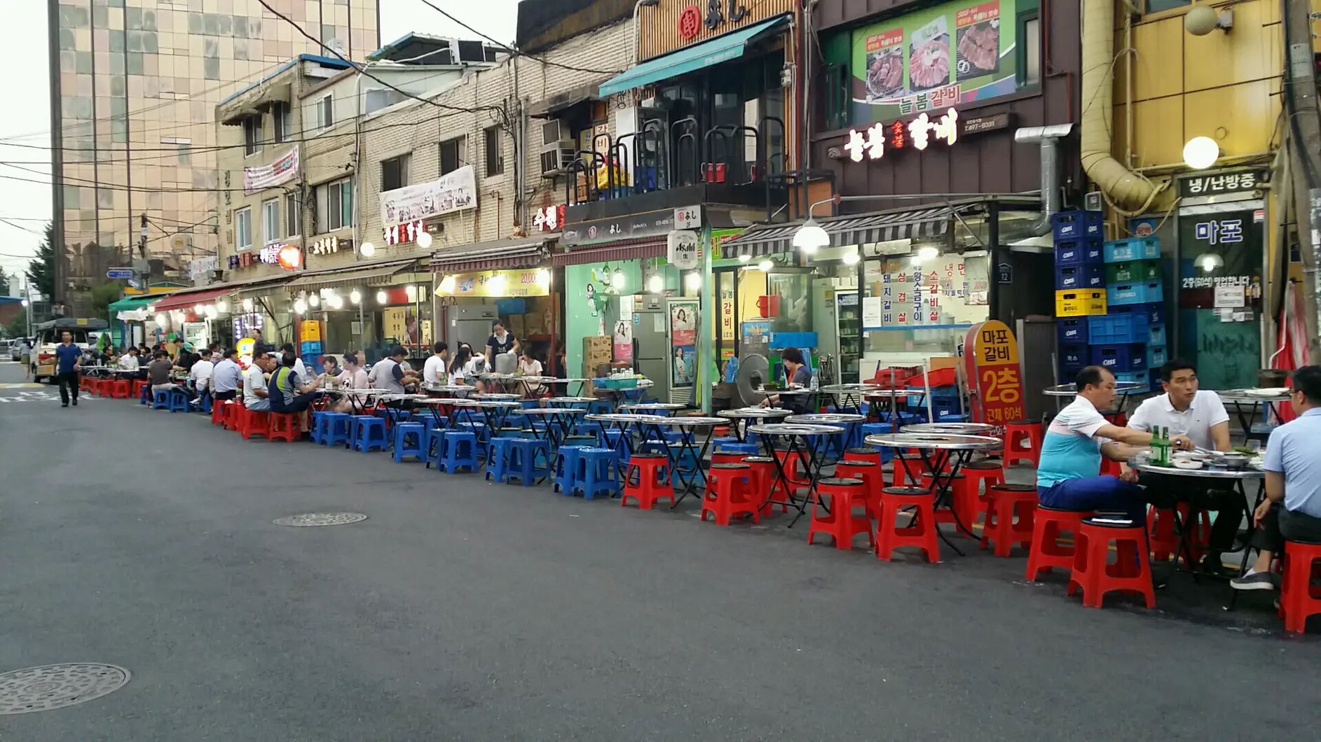 Red and blue plastic stools and folding tables set out along a roadside