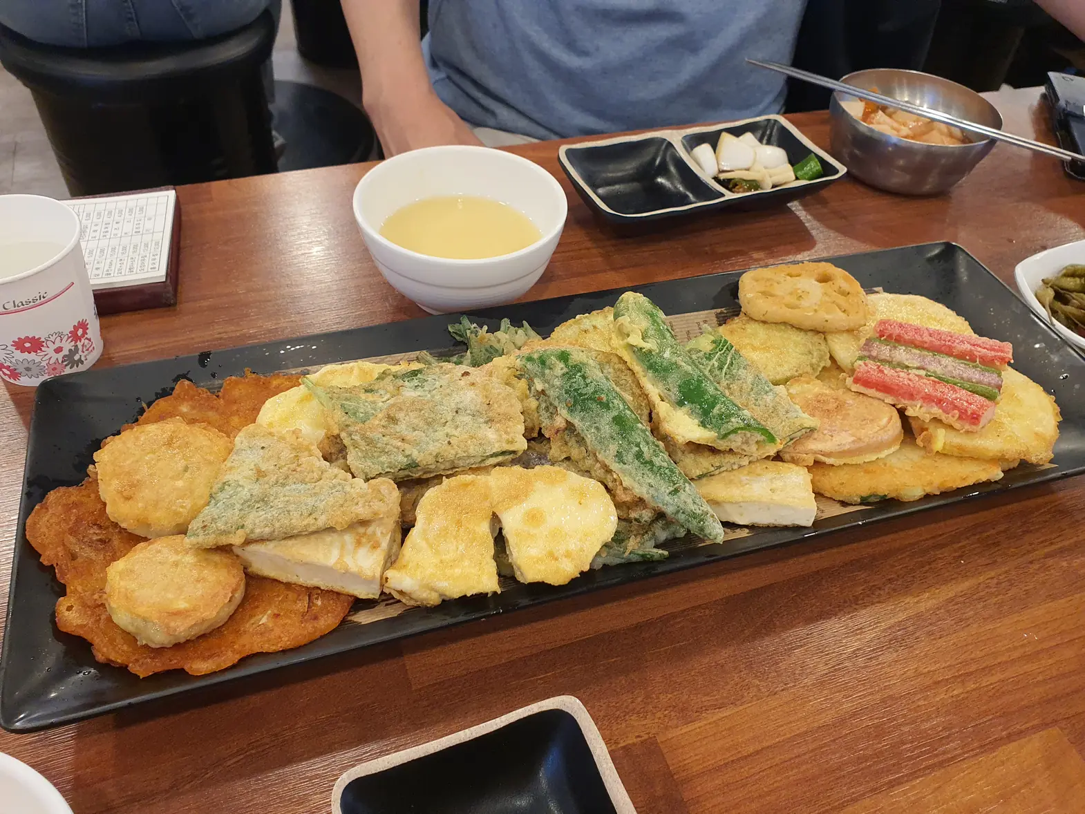 Long plate of assorted Korean pancakes on a table with side dishes