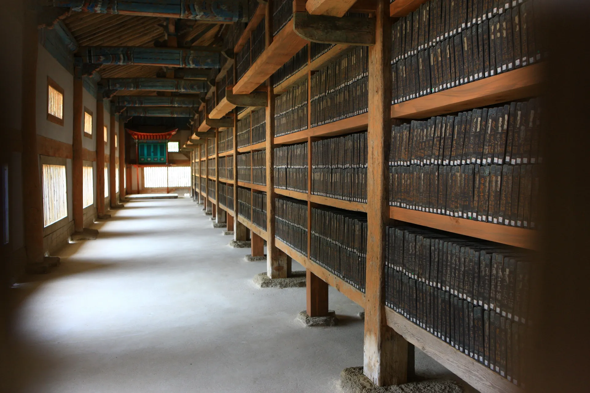 Rows of wooden printing blocks filling shelves along the length of a timber hall interior